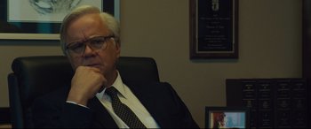 Movie still from “Dark Waters” (2019), directed by Todd Haynes – An older man sitting in a chair in front of a wall; Close Up shot, Low angle