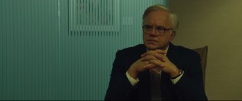 Movie still from “Dark Waters” (2019), directed by Todd Haynes – A man in a suit and tie sitting in front of a wall; Close Up shot, Over the shoulder angle