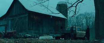 Movie still from “Dark Waters” (2019), directed by Todd Haynes – A man standing next to a truck in front of a barn; Extreme Wide shot, Low angle