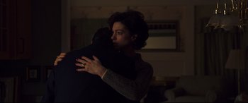 Movie still from “Dark Waters” (2019), directed by Todd Haynes – A man and a woman hugging in a dark room; Medium shot, Low angle