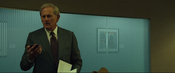 Movie still from “Dark Waters” (2019), directed by Todd Haynes – A man in a suit and tie holding a paper; Medium shot, Over the shoulder angle