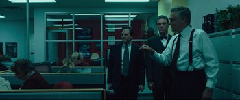 Movie still from “Dark Waters” (2019), directed by Todd Haynes – A couple of men standing next to each other in a room; Medium shot, Low angle