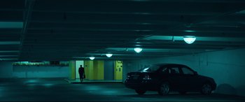Movie still from “Dark Waters” (2019), directed by Todd Haynes – A man walking in a parking garage at night; Extreme Wide shot, Low angle