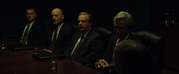 Movie still from “Dark Waters” (2019), directed by Todd Haynes – A group of men sitting at a table in a dark room; Medium shot, Over the shoulder angle