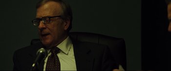 Movie still from “Dark Waters” (2019), directed by Todd Haynes – An older man wearing a suit and tie sitting in an office chair; Close Up shot, Over the shoulder angle