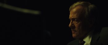 Movie still from “Dark Waters” (2019), directed by Todd Haynes – A person's face in the dark; Close Up shot, Over the shoulder angle