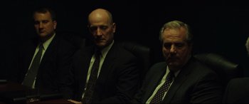 Movie still from “Dark Waters” (2019), directed by Todd Haynes – A couple of men sitting next to each other in a room; Medium shot, Over the shoulder angle