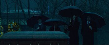 Movie still from “Dark Waters” (2019), directed by Todd Haynes – A group of people standing next to each other holding umbrellas; Medium shot, High angle