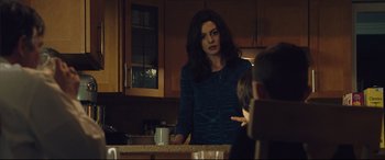 Movie still from “Dark Waters” (2019), directed by Todd Haynes – A woman standing in a kitchen talking to a man; Medium shot, Over the shoulder angle