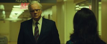 Movie still from “Dark Waters” (2019), directed by Todd Haynes – A man in a suit and tie standing next to a woman in a suit; Medium shot, Over the shoulder angle