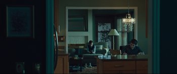 Movie still from “Dark Waters” (2019), directed by Todd Haynes – A man sitting on top of a couch in a living room; Wide shot, Over the shoulder angle