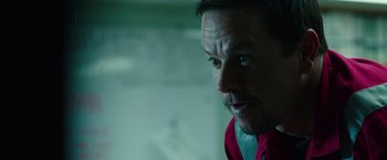 Movie still from “Deepwater Horizon” (2016), directed by Peter Berg – A person wearing a red shirt; Close Up shot, Over the shoulder angle