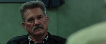 Movie still from “Deepwater Horizon” (2016), directed by Peter Berg – An older man with a mustache is looking at the camera; Close Up shot, Over the shoulder angle