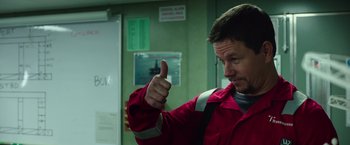 Movie still from “Deepwater Horizon” (2016), directed by Peter Berg – A man giving a thumbs up while wearing a red jacket; Close Up shot, Low angle