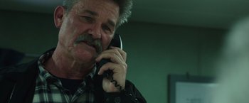 Movie still from “Deepwater Horizon” (2016), directed by Peter Berg – An older man talking on a phone while wearing a plaid shirt; Close Up shot, Low angle