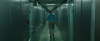 Movie still from “Deepwater Horizon” (2016), directed by Peter Berg – A man walking down a long hallway in a building; Wide shot, Low angle