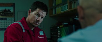 Movie still from “Deepwater Horizon” (2016), directed by Peter Berg – A man in a red shirt is looking at the camera; Close Up shot, Over the shoulder angle
