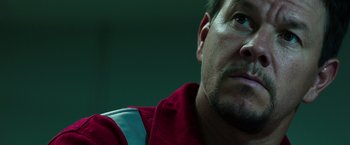 Movie still from “Deepwater Horizon” (2016), directed by Peter Berg – A man in a red shirt; Close Up shot, Low angle