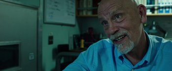 Movie still from “Deepwater Horizon” (2016), directed by Peter Berg – An older man in a blue shirt is smiling for the camera; Close Up shot, Over the shoulder angle