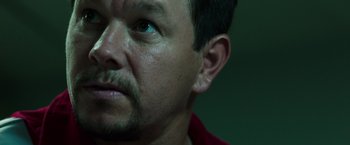 Movie still from “Deepwater Horizon” (2016), directed by Peter Berg – A man's face with a green background; Close Up shot, Low angle