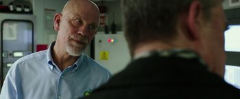 Movie still from “Deepwater Horizon” (2016), directed by Peter Berg – A man in a blue shirt is talking to another man in a black suit; Close Up shot, Over the shoulder angle