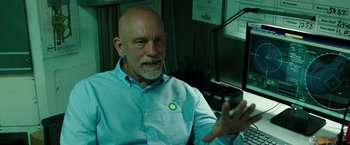 Movie still from “Deepwater Horizon” (2016), directed by Peter Berg – An older bald man wearing a blue button up shirt; Close Up shot, Over the shoulder angle