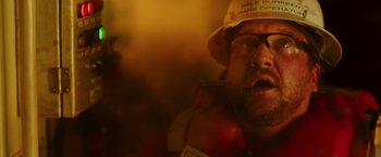 Movie still from “Deepwater Horizon” (2016), directed by Peter Berg – A person wearing a hat and glasses; Close Up shot, Low angle