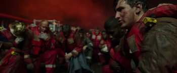Movie still from “Deepwater Horizon” (2016), directed by Peter Berg – A group of people in red and white uniforms; Medium shot, Over the shoulder angle