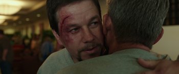 Movie still from “Deepwater Horizon” (2016), directed by Peter Berg – A man with bruising on his face and cheek; Close Up shot, Over the shoulder angle