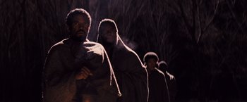 Movie still from “Django Unchained” (2012), directed by Quentin Tarantino – A group of men standing next to each other in the dark; Medium shot, Low angle