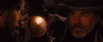 Movie still from “Django Unchained” (2012), directed by Quentin Tarantino – A man with a beard and a hat looking at a lamp; Close Up shot, Low angle