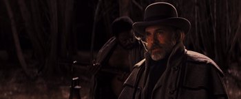 Movie still from “Django Unchained” (2012), directed by Quentin Tarantino – A man with a beard wearing a hat and holding a gun; Close Up shot, Over the shoulder angle