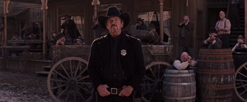 Movie still from “Django Unchained” (2012), directed by Quentin Tarantino – A man in a black suit and a black cowboy hat; Medium shot, Low angle