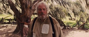 Movie still from “Django Unchained” (2012), directed by Quentin Tarantino – An old man with a beard and a white beard; Medium shot, Low angle