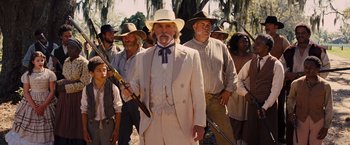 Movie still from “Django Unchained” (2012), directed by Quentin Tarantino – A group of men standing next to each other holding guns; Medium shot, Low angle