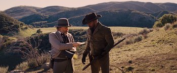 Movie still from “Django Unchained” (2012), directed by Quentin Tarantino – Two men standing in a field with a rifle; Medium shot, Over the shoulder angle