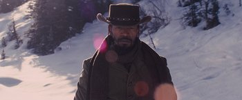 Movie still from “Django Unchained” (2012), directed by Quentin Tarantino – A man wearing a cowboy hat and a scarf; Close Up shot, Low angle