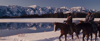 Movie still from “Django Unchained” (2012), directed by Quentin Tarantino – A man riding a horse in the snow near a body of water; Wide shot, Low angle