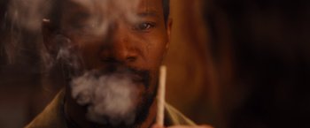 Movie still from “Django Unchained” (2012), directed by Quentin Tarantino – A person holding a cigarette in his mouth; Extreme Close Up shot, Over the shoulder angle