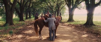 Movie still from “Django Unchained” (2012), directed by Quentin Tarantino – A man in a hat is on top of a brown horse; Wide shot, Over the shoulder angle