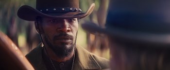 Movie still from “Django Unchained” (2012), directed by Quentin Tarantino – A person wearing a cowboy hat; Close Up shot, Over the shoulder angle