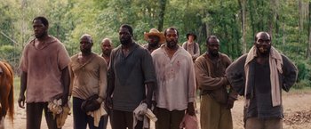 Movie still from “Django Unchained” (2012), directed by Quentin Tarantino – A group of men standing next to each other in front of a forest; Wide shot, High angle