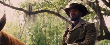 Movie still from “Django Unchained” (2012), directed by Quentin Tarantino – A man wearing a hat and a jacket; Medium shot, Low angle
