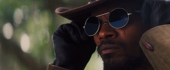 Movie still from “Django Unchained” (2012), directed by Quentin Tarantino – A person wearing sunglasses and a hat; Close Up shot, Low angle