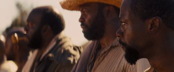 Movie still from “Django Unchained” (2012), directed by Quentin Tarantino – A group of men standing next to each other in a field; Close Up shot, Over the shoulder angle