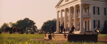 Movie still from “Django Unchained” (2012), directed by Quentin Tarantino – A group of people standing in front of a large building; Extreme Wide shot, Low angle