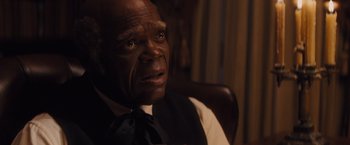 Movie still from “Django Unchained” (2012), directed by Quentin Tarantino – An older man wearing a vest and a tie; Close Up shot, Over the shoulder angle