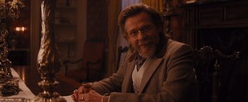 Movie still from “Django Unchained” (2012), directed by Quentin Tarantino – A man sitting in a chair holding a glass of wine; Medium shot, Over the shoulder angle