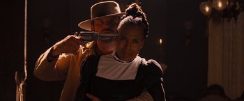 Movie still from “Django Unchained” (2012), directed by Quentin Tarantino – A man and a woman holding guns in a dark room; Close Up shot, Over the shoulder angle