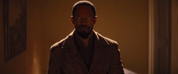 Movie still from “Django Unchained” (2012), directed by Quentin Tarantino – A man in a brown jacket is looking at the camera; Close Up shot, Over the shoulder angle